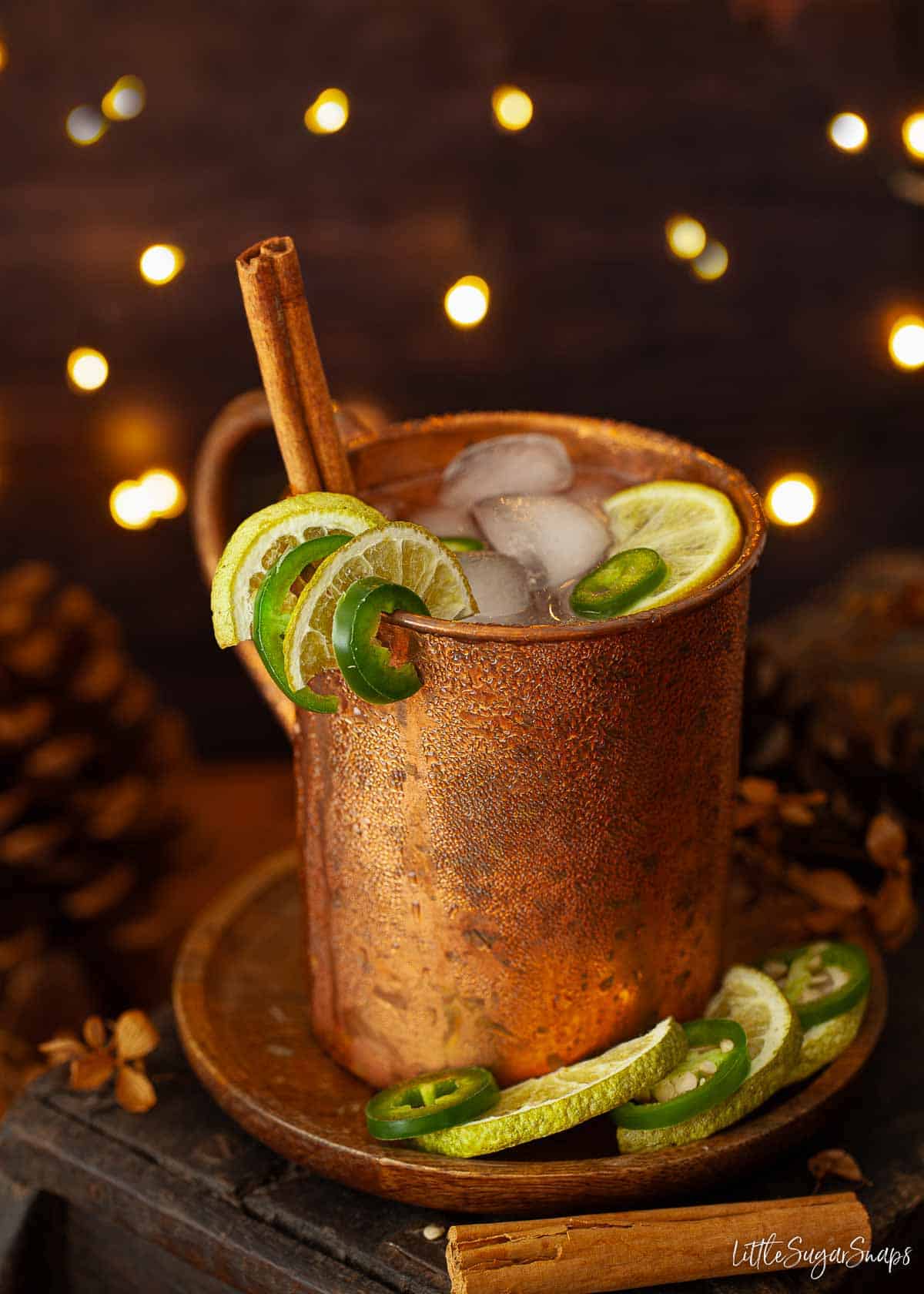 Tequila mule in a copper mug with cinnamon, lime and chilli garnish.