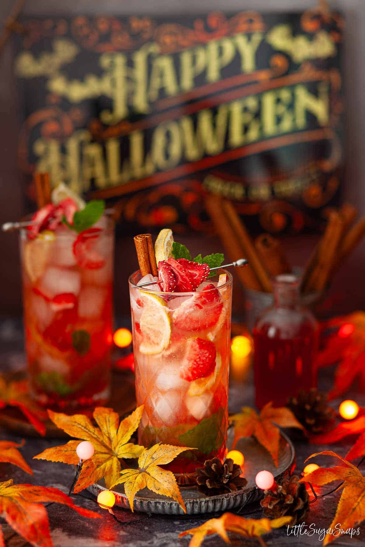 A red cocktail for halloween with themed decorations.