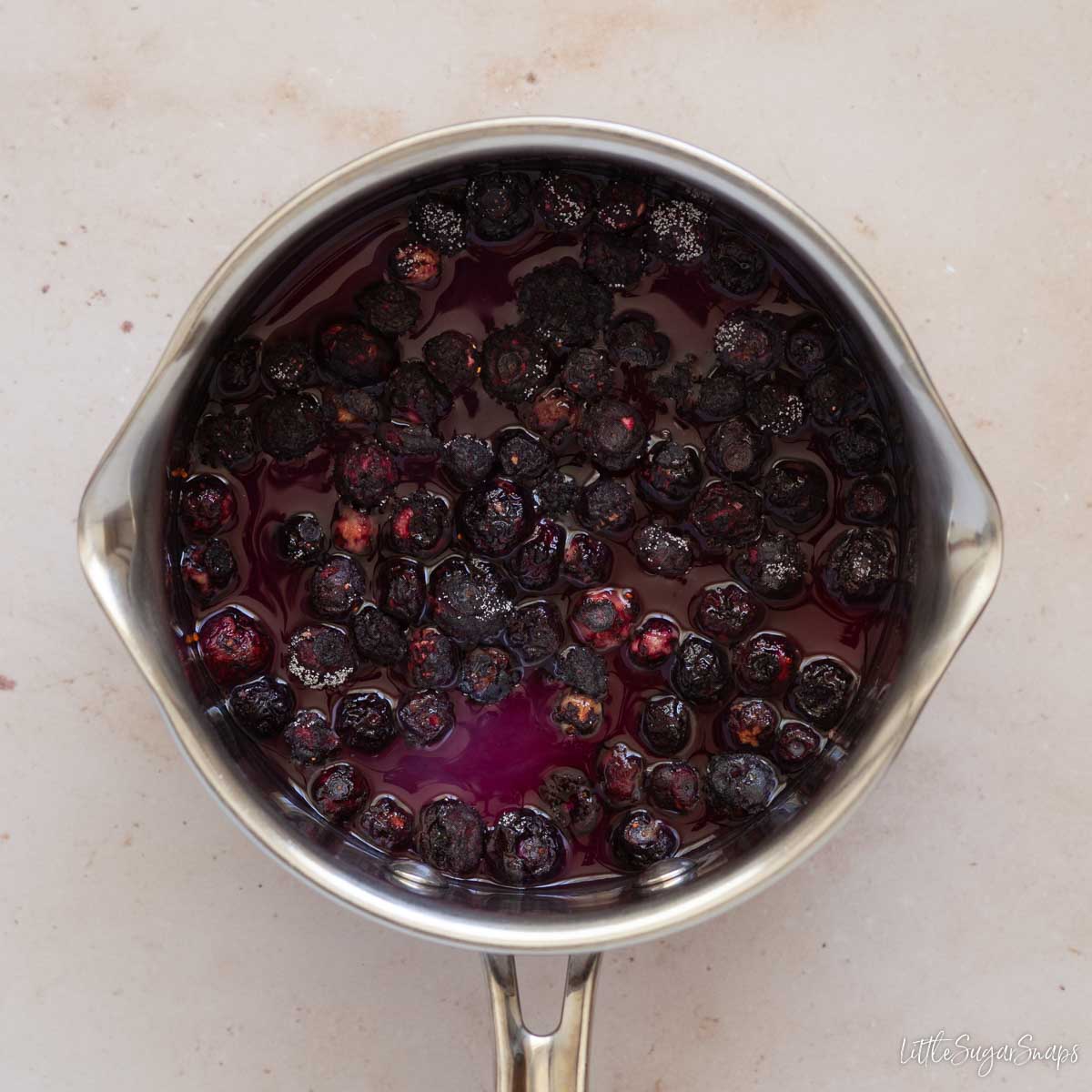 Blueberries in a pan with sugar and water.