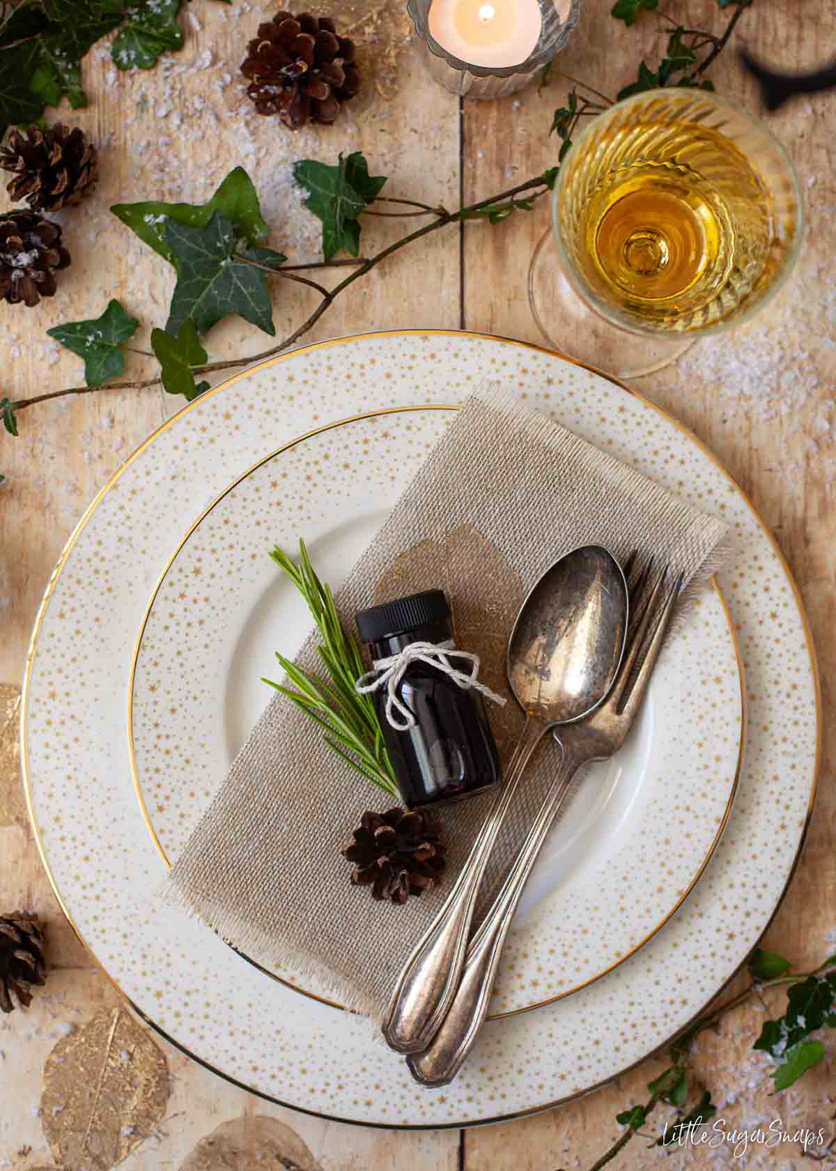A small bottle of blueberry syrup used as a table favourin a festive setting.