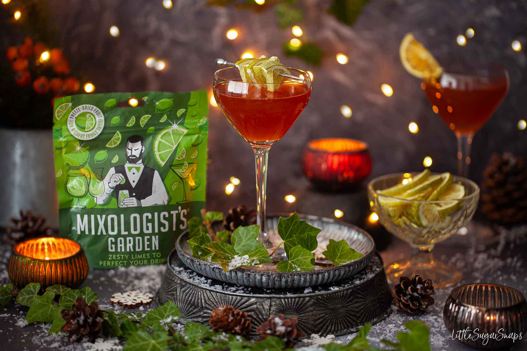 Vintage Charlie Chaplin cocktails with dried lime garnishes in a festive setting.