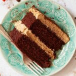 Close up of a slice of spiced mocha cake sandwiched with coffee cream on a blue plate.
