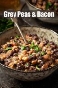Labelled grey peys and bacon made from carlin peas in a bowl with parsley garnish.