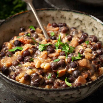 Close-up of grey peys and bacon made from carlin peas in a bowl with parsley garnish.