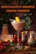 A glass of chocolate cream liqueur garnished with freeze-dried orange. With text overlay.