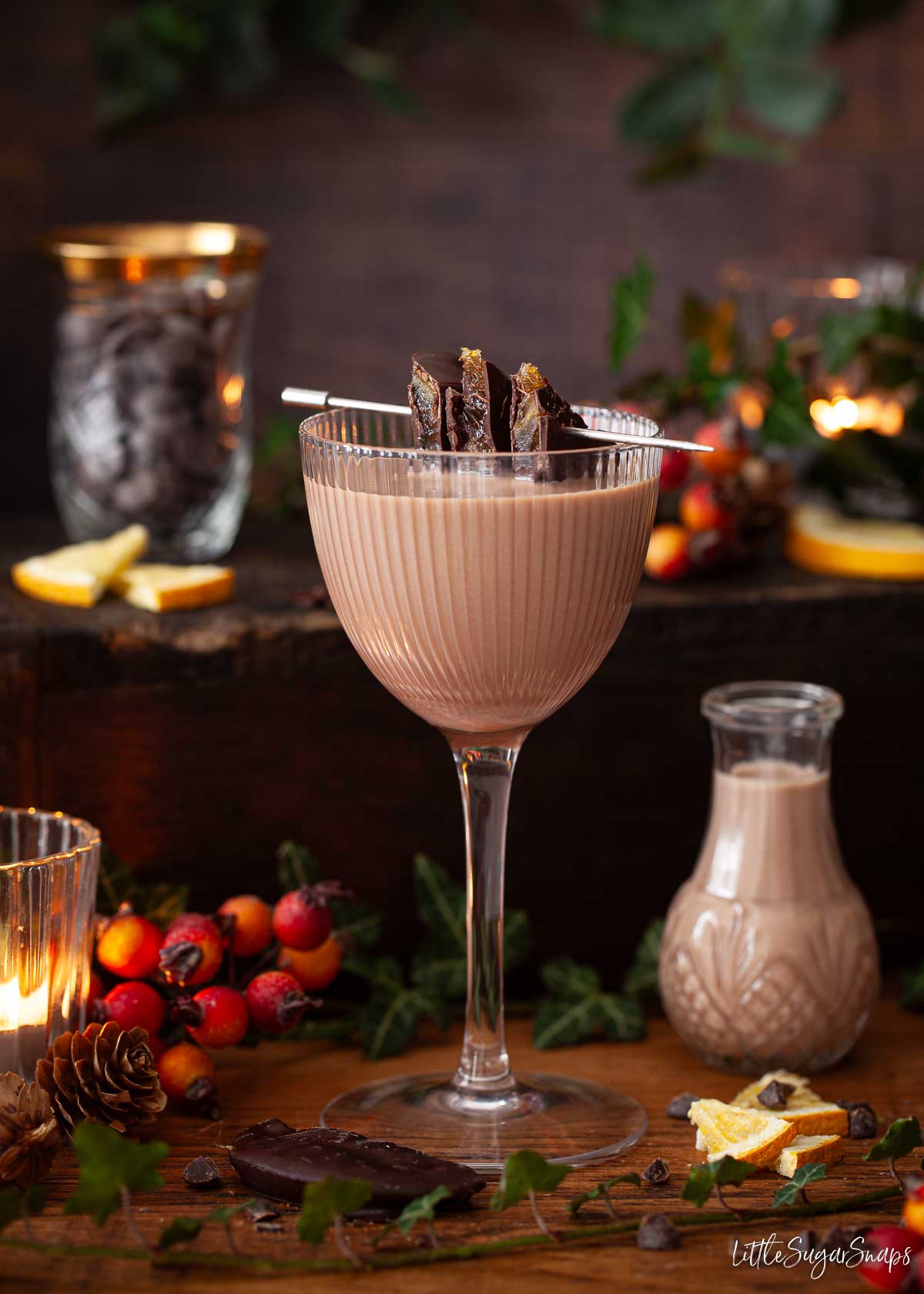 A glass of chocolate orange cream liqueur with chocolate covered candied orange as a garnish.