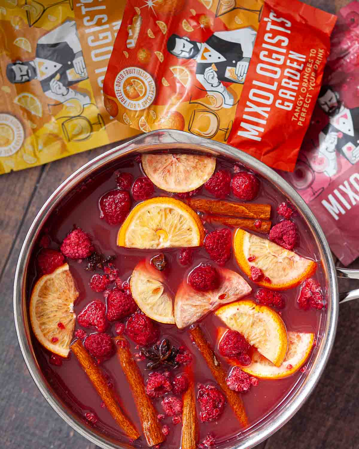 Fruit punch mocktail with cinnamon steeping in a saucepan.