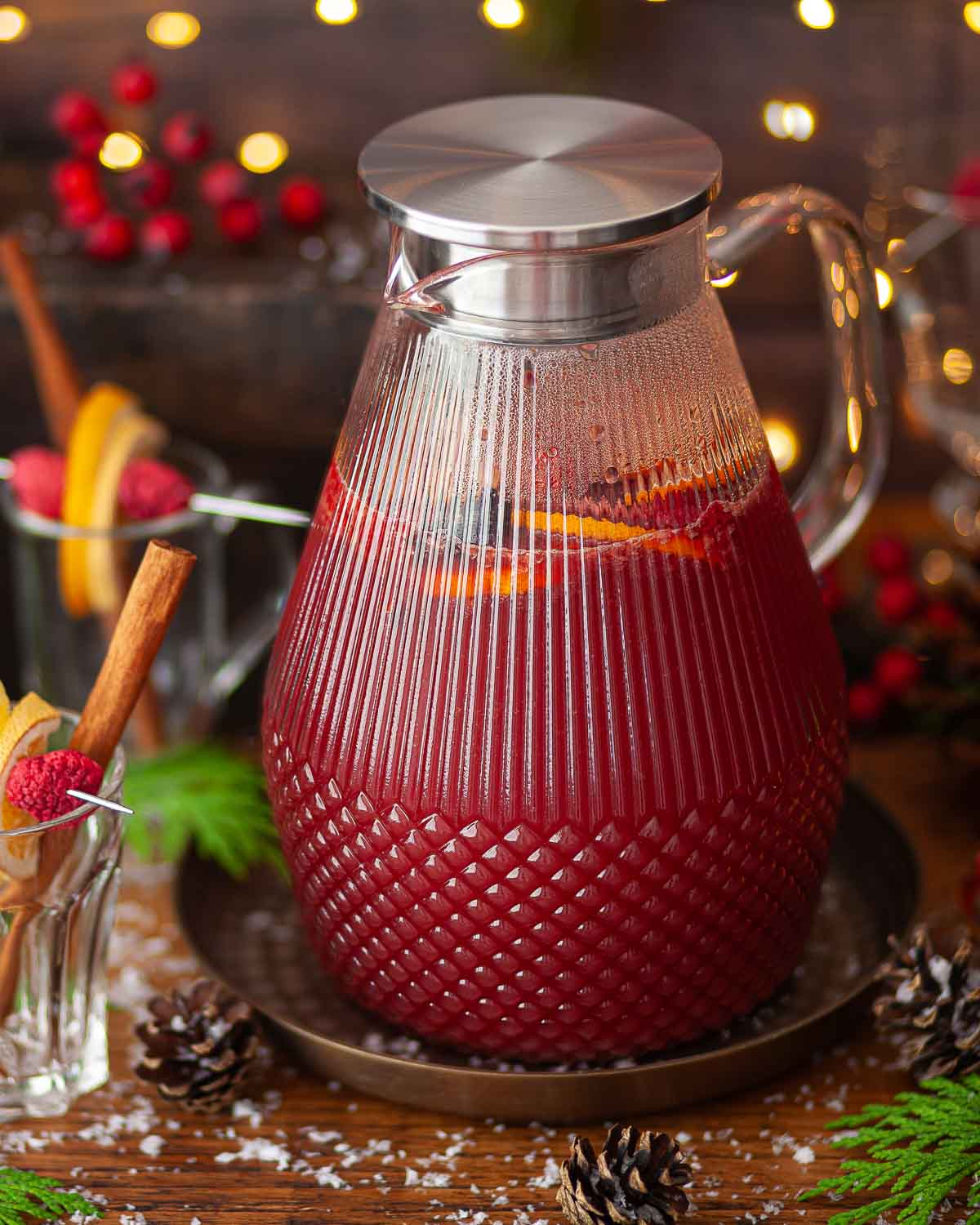 Warm fruit punch in a heatproof jug in a festive setting.