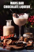 Mars Bar Liqueur served over ice in a stemmed glass with chocolate bars alongside it with text overlay.