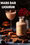 Labelled image of a bottle of Mars Bar liqueur with a serving in a glass behind it.