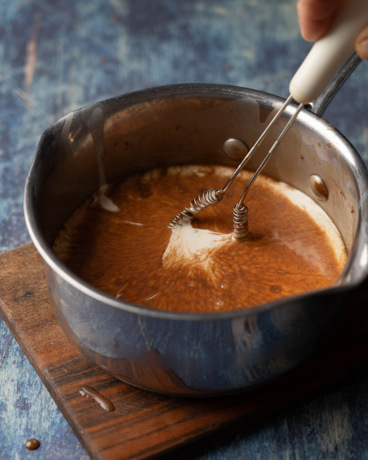 Chocolate being stirred into hot cream.