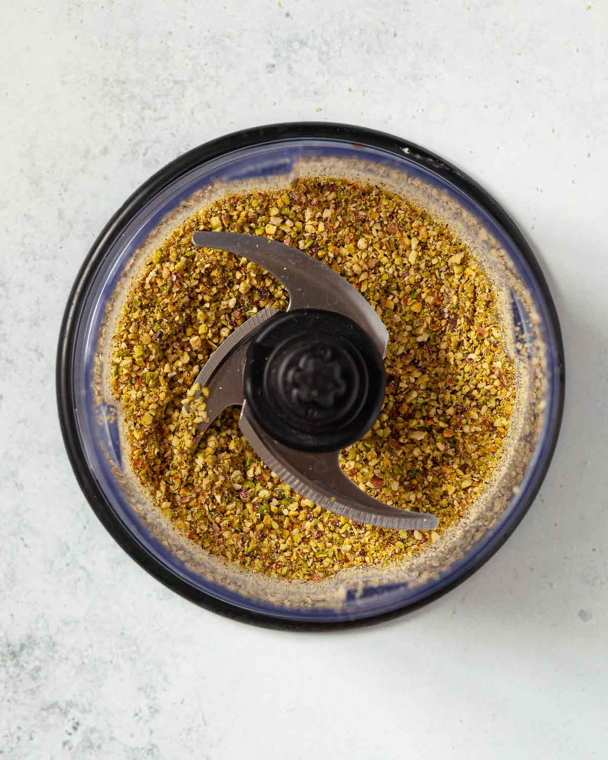 Partially ground pistachio nuts in a food processor.
