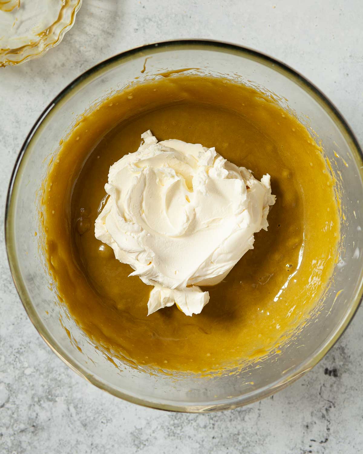 Mascarpone cheese in a bowl with pistachio batter.