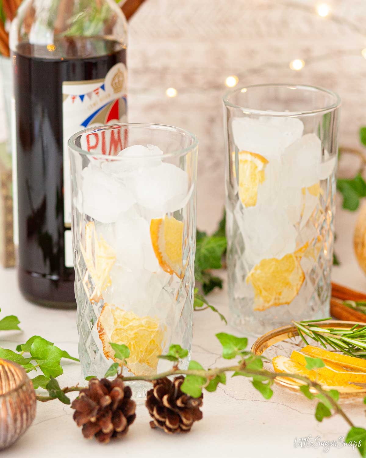 Ice and freeze-dried orange slices layered in glasses.