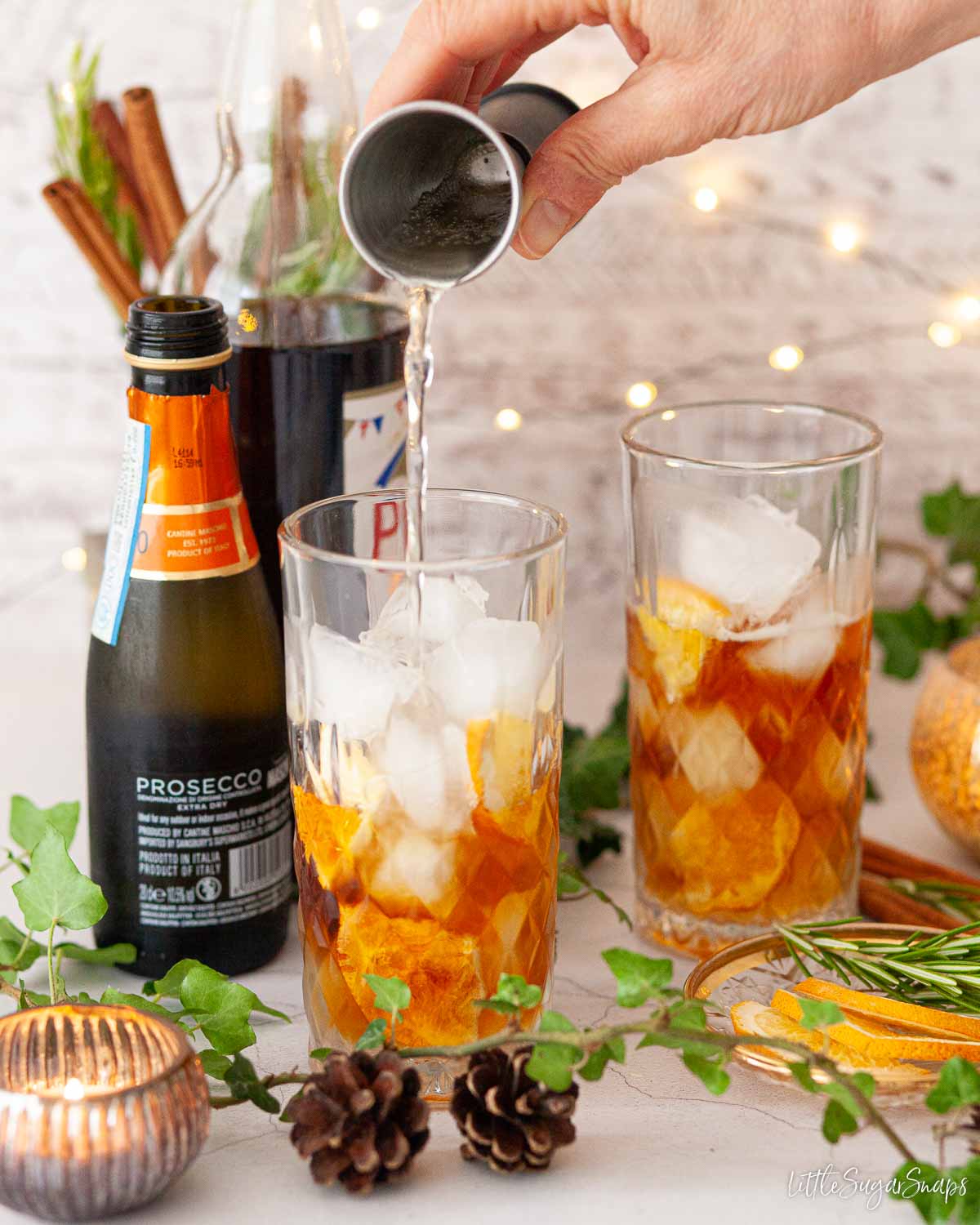 An orange and ginger cocktail being assembled in a glass.