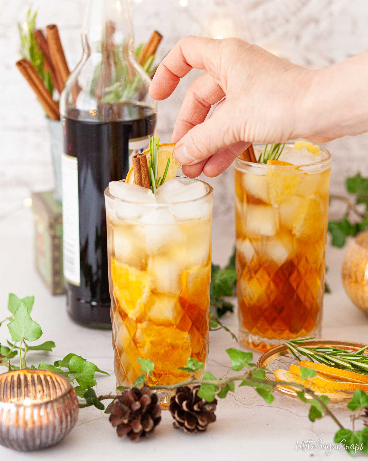 Person adding a garnish to a ginger ale Pimms drink.