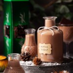 A bottle of homemade After Eight liqueur with a box of mint thin chocolates in the background.