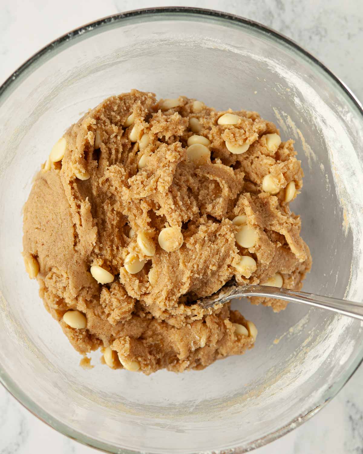 White chocolate chip and stem ginger cookie dough in a bowl.