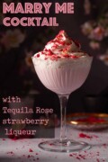 Labelled creamy strawberry liqueur cocktail topped with cream and crushed freeze-dried raspberries.