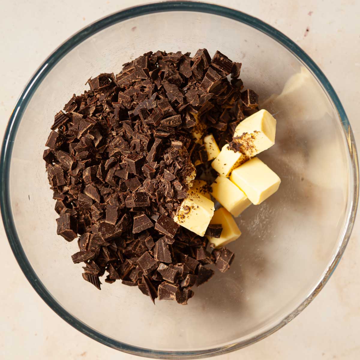 Chopped chocolate and cubed butter in a mixing bowl.
