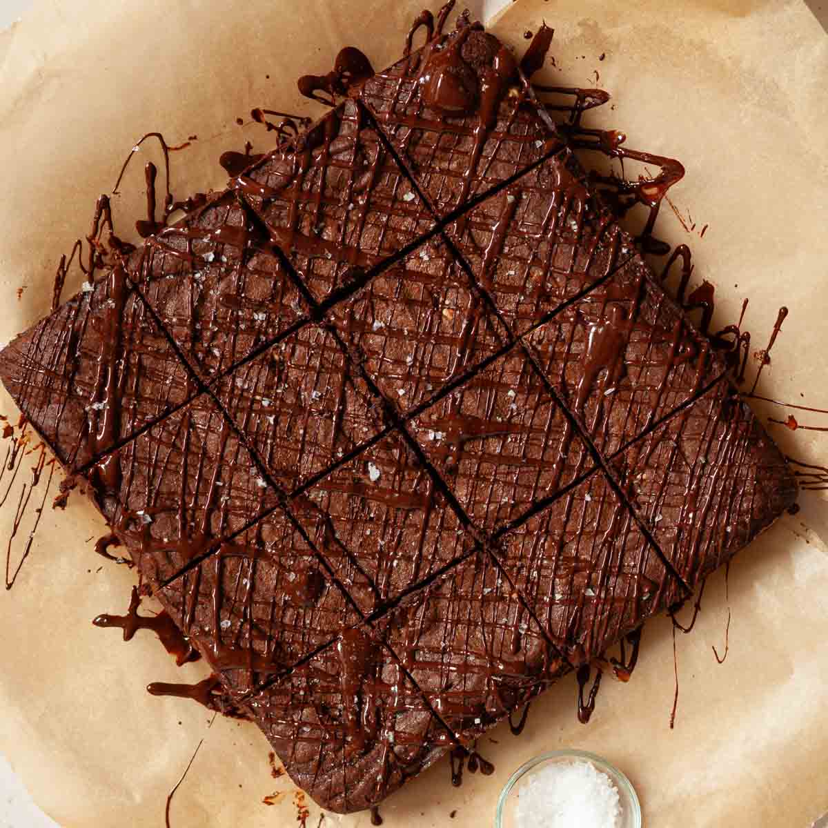 Dark chocolate drizzled over cut up brownies with seasalt sprinkled on top.