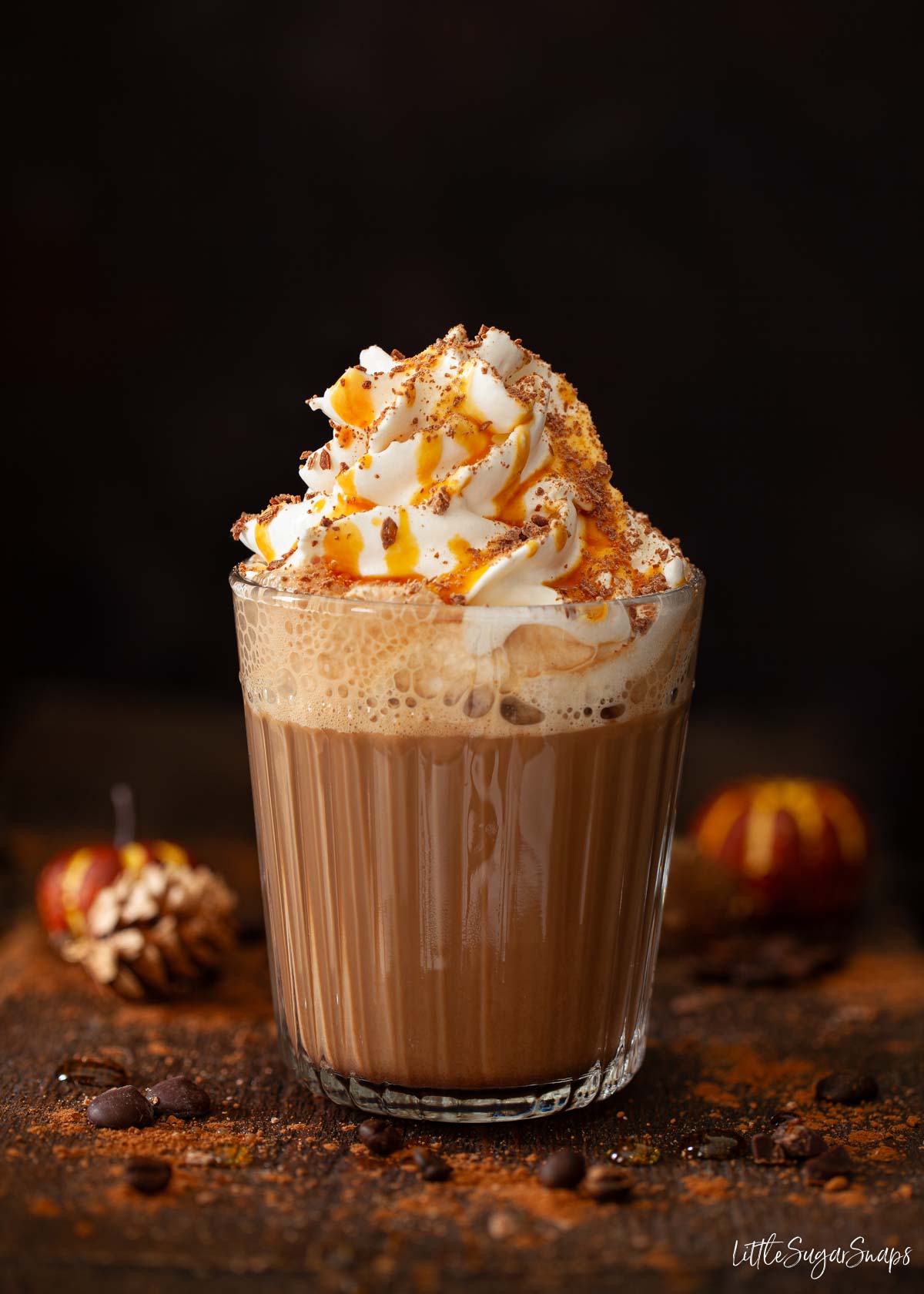 Caramel mocha latte drink topped with whipped cream, chocolate flakes and caramel syrup.