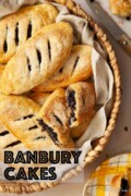 Labelled image of Banbury cakes in a wicker tray with one cake cut in half.