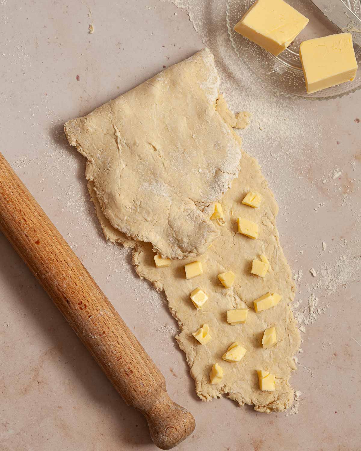 Flaky pastry being made: cubes of butter being encased in rolled out pastry.