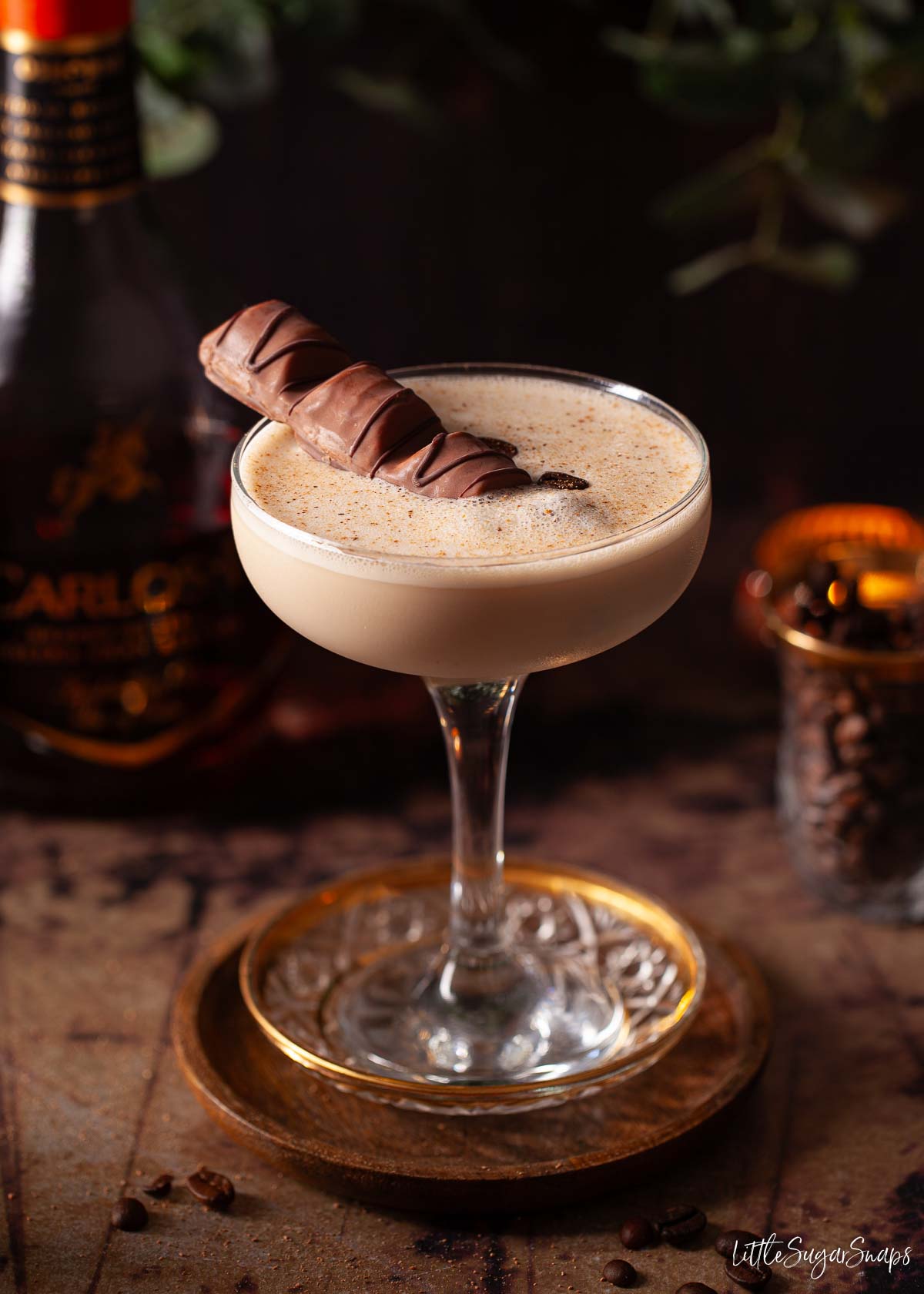 After dinner cocktail with nutmeg and chocolate bar garnish with a bottle of brandy.