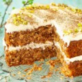 Cut into carrot and pineapple cake with cream cheese frosting and pistachio nuts.