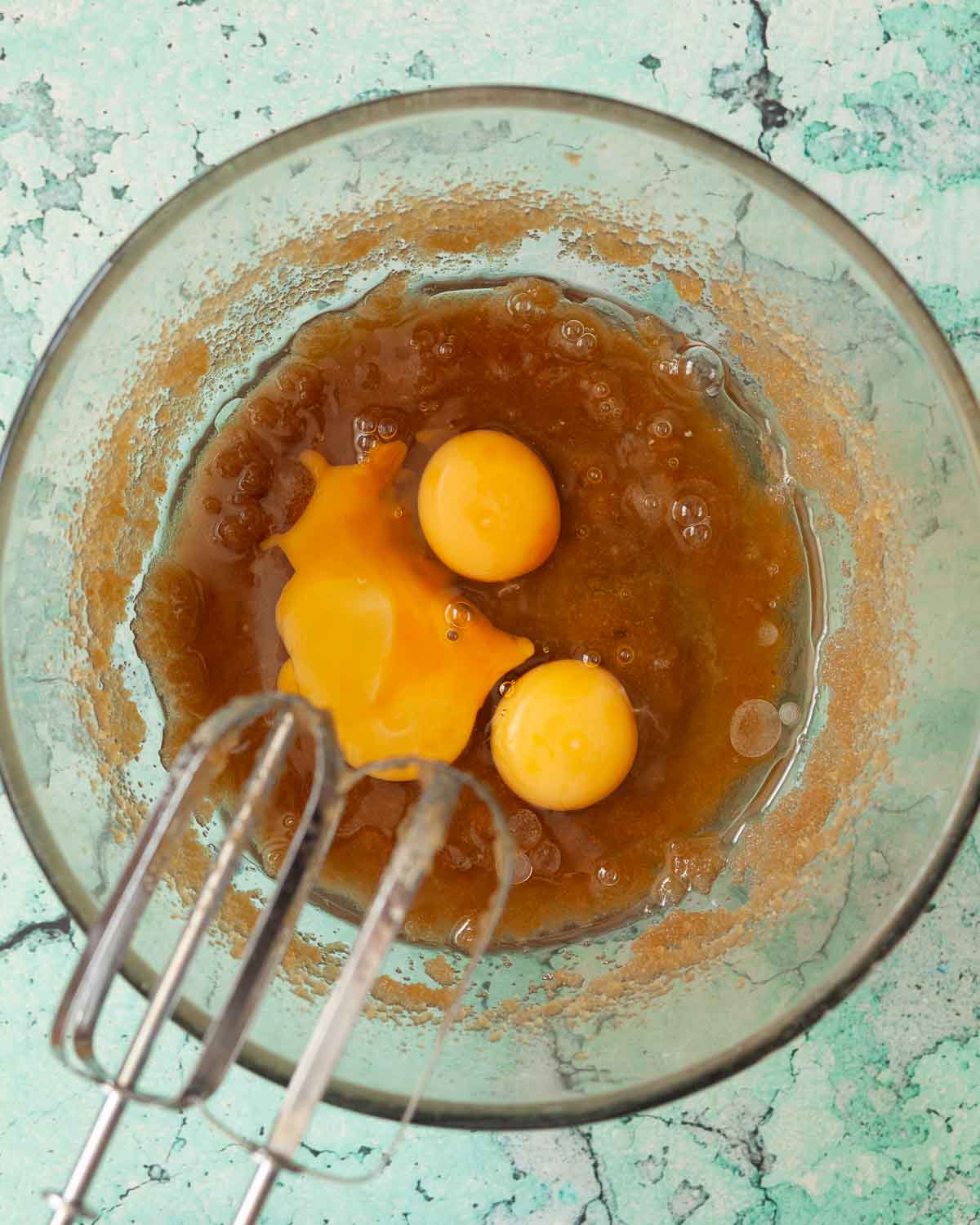 Eggs in a bowl with oil and sugar to make cakebatter.