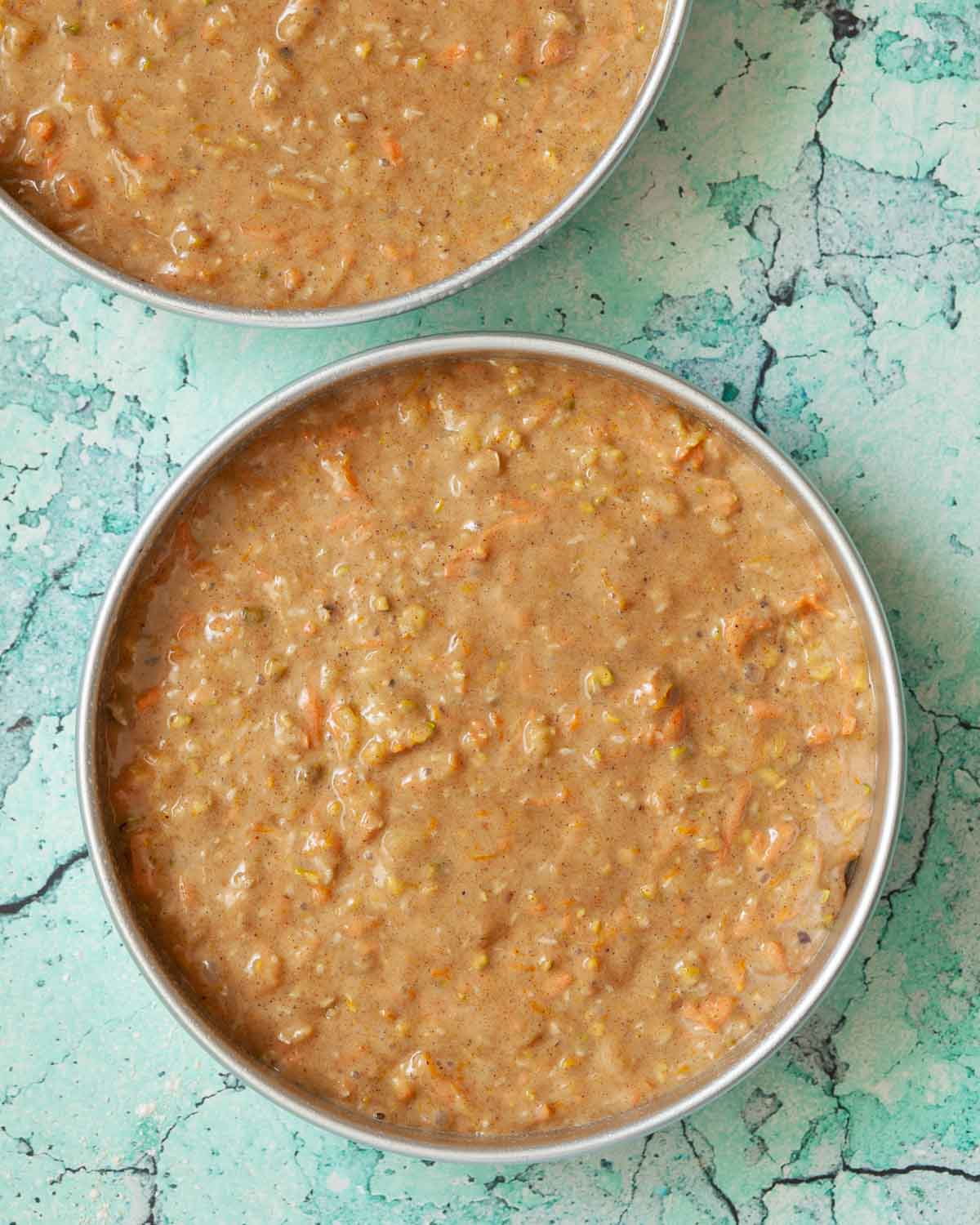 Carrot cake batter in 2 baking tins ready to be baked.