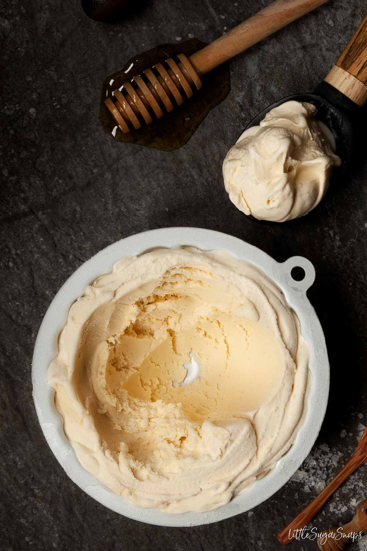 A tub of salted honey ice cream with some of it having been scooped out.