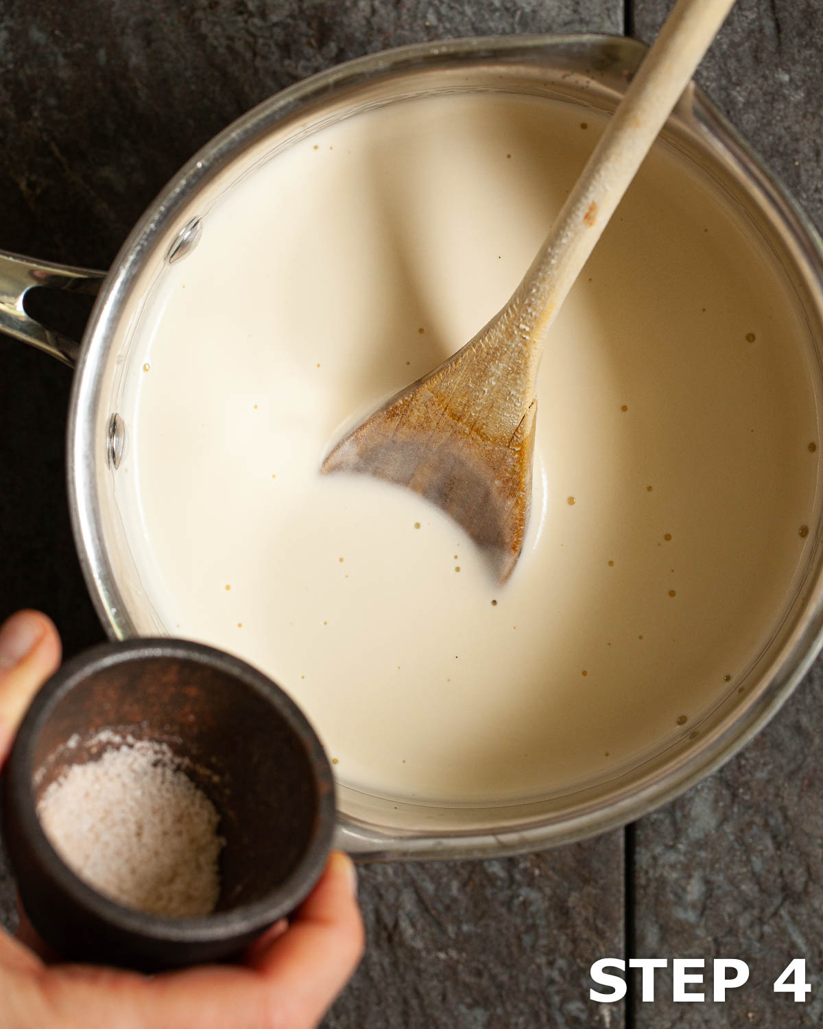 Person adding sea salt to ice cream base in a pan.