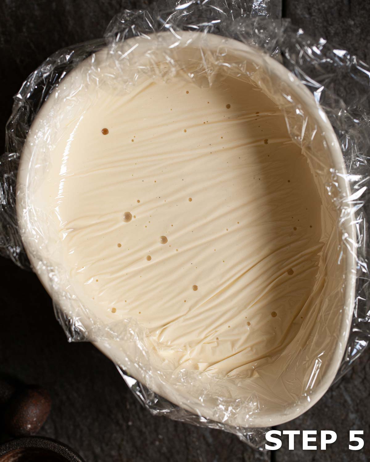 Ice cream base in a bowl covered with food wrap to stop a skin forming.