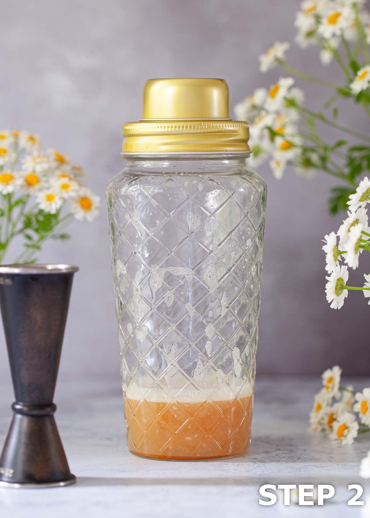 A recently shaken cocktail in a cocktail shaker.