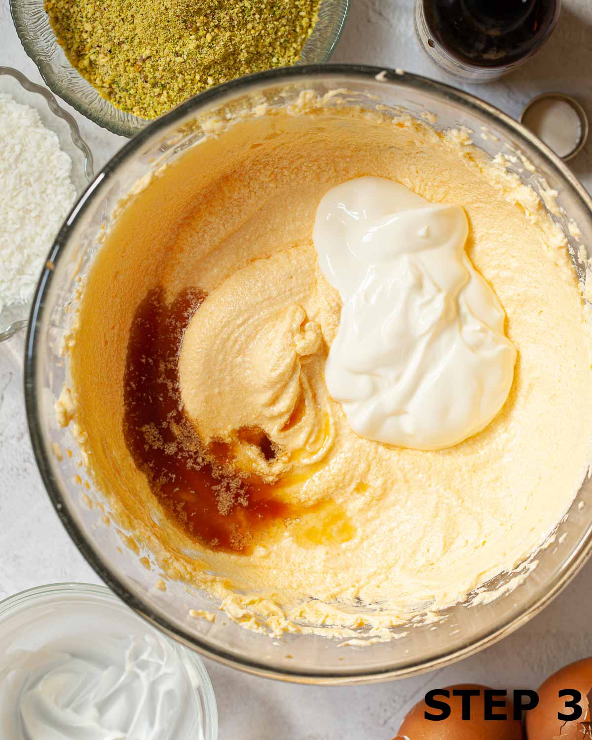 Soured cream and vanilla extract in a bowl with cake batter ready to be combined.
