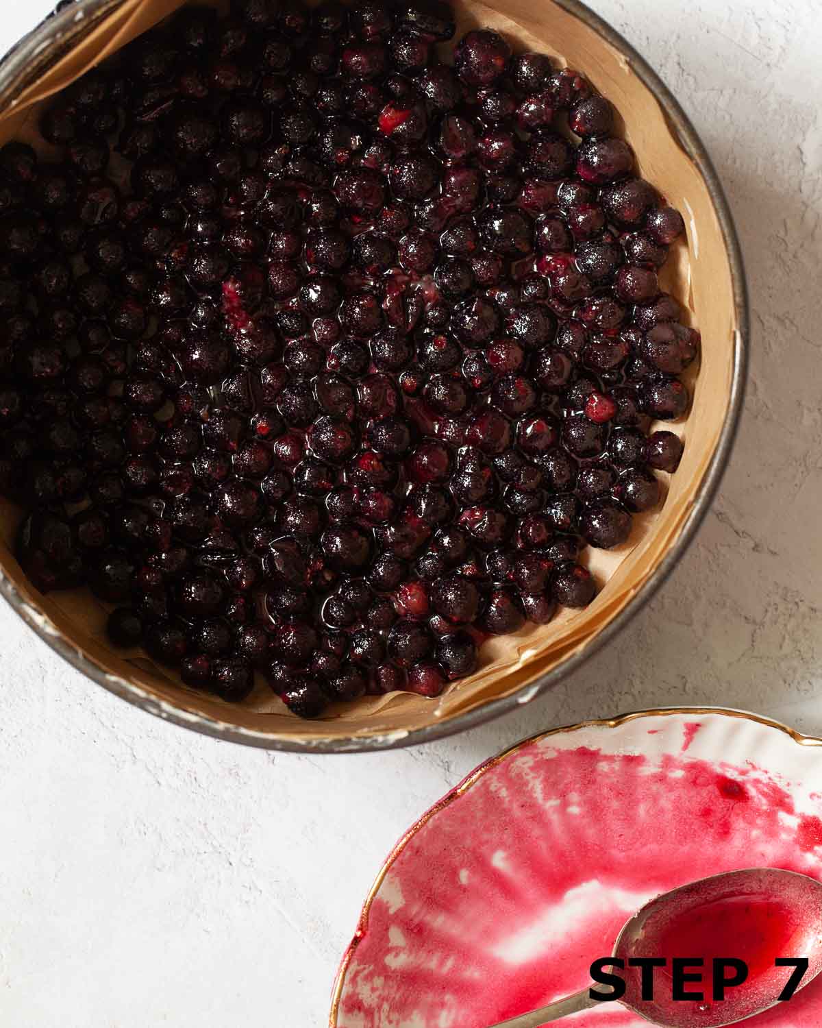 Blackcurrants in the base of a lined baking tin.