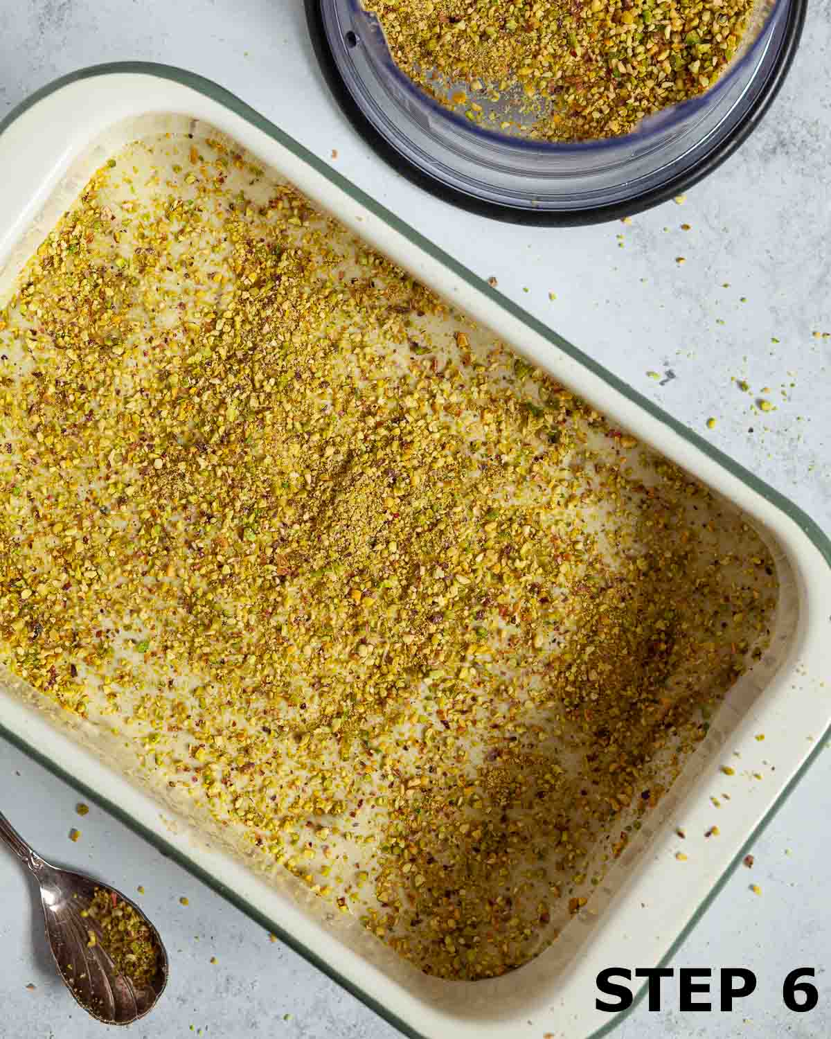 Pistachio tiramisu being assembled with layers of pistachio cream and nuts.