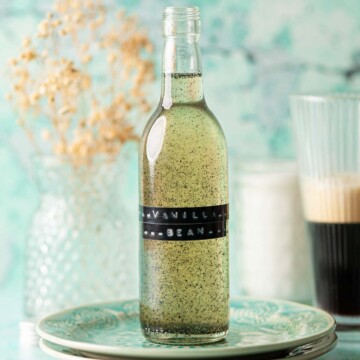 A labelled bottle of vanilla bean simple syrup on a plate.