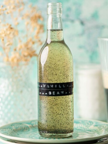 A labelled bottle of vanilla bean simple syrup on a plate.