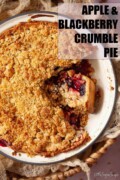 Labelled apple and blackberry crumble pie in a pan with a slice cut.