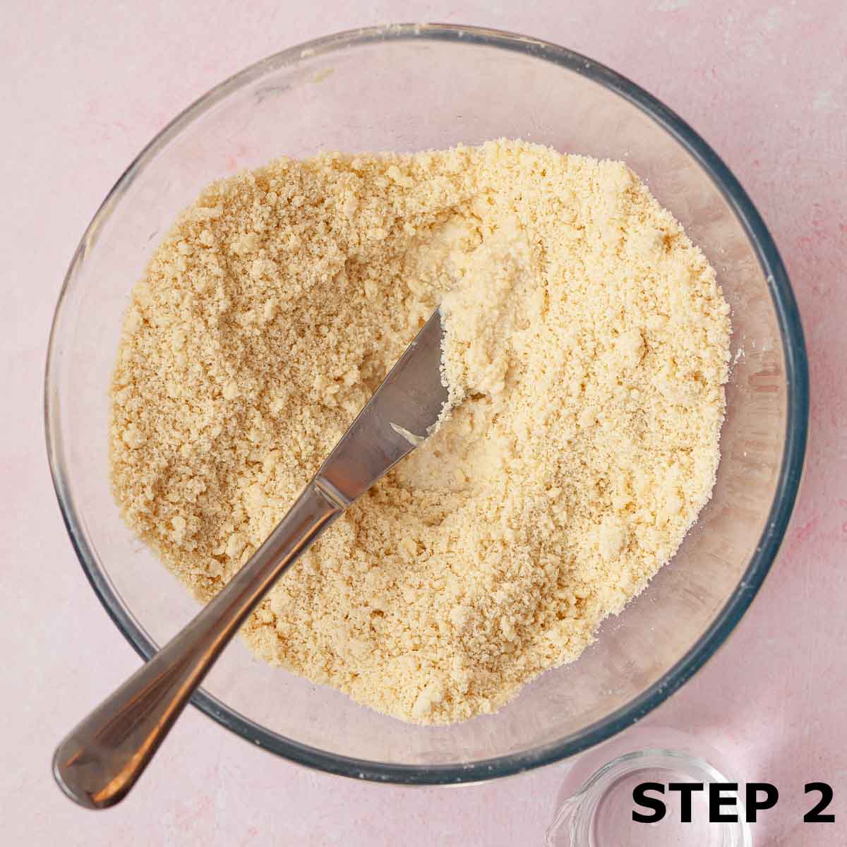 Bowl containing rubbed flour and butter with water about to be mixed in.