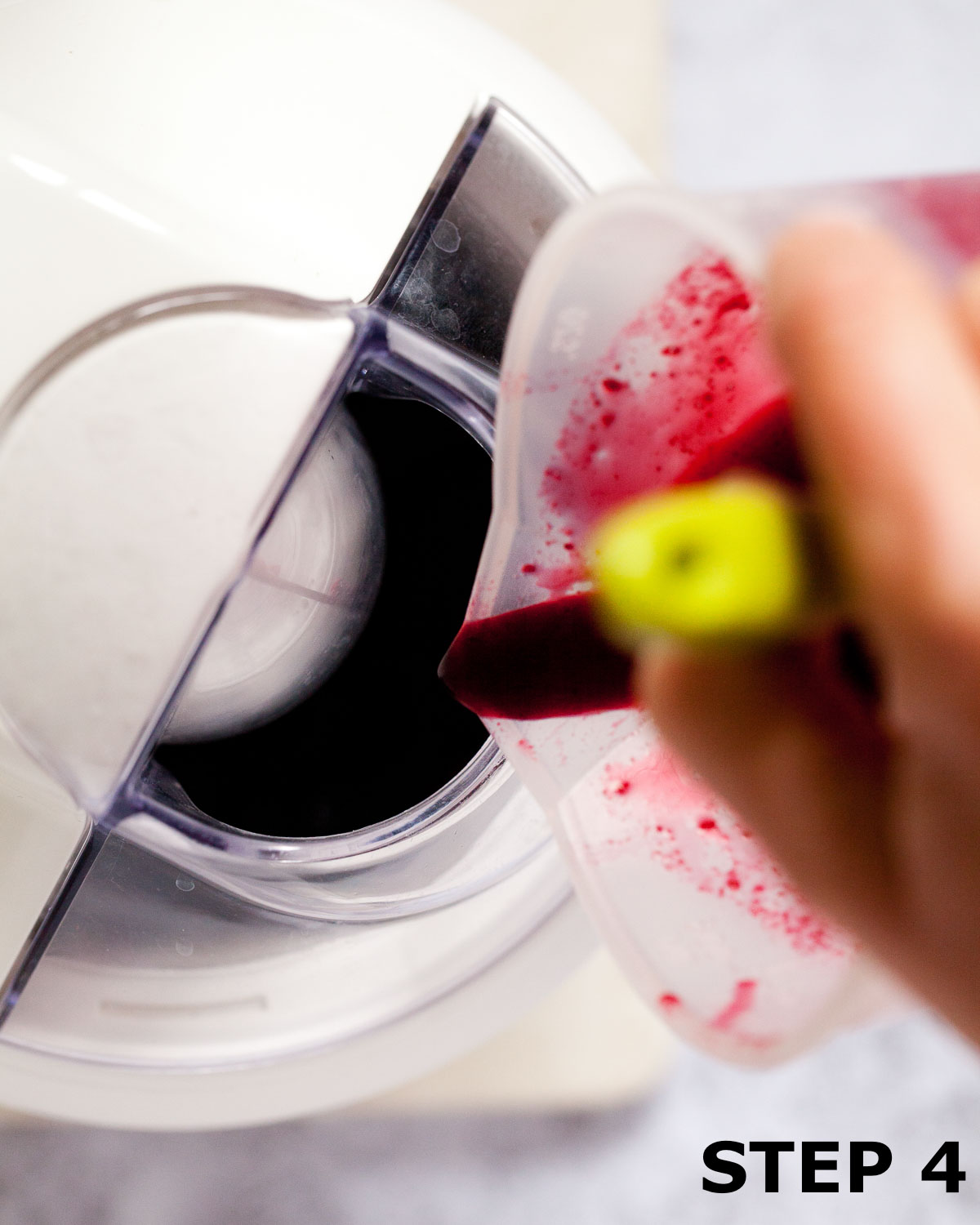 Blackcurrant sorbet mixture being poured into an ice cream churner.