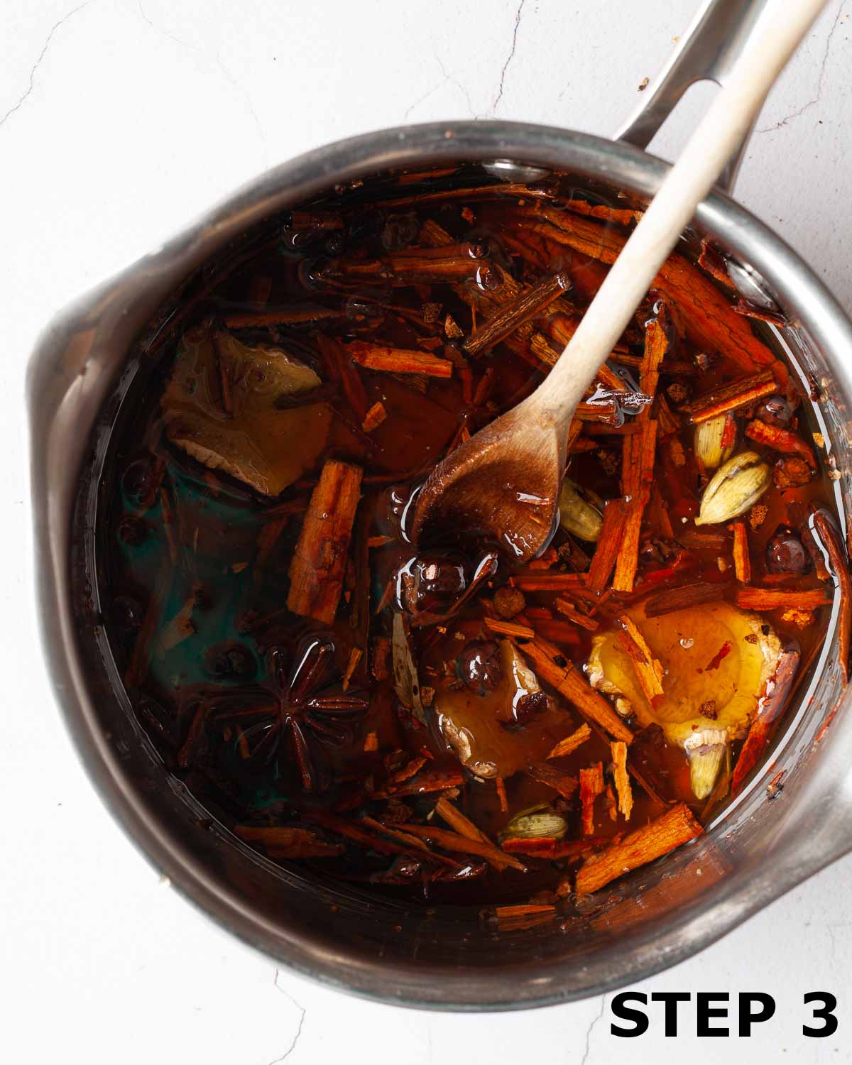 Spices infusing in simple syrup in a pan.