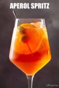 Labelled Aperol spritz Veneziano with orange and olive garnish.