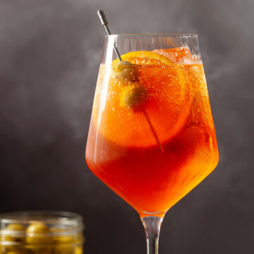 Spritz Veneziano with orange slice and green olive garnish.