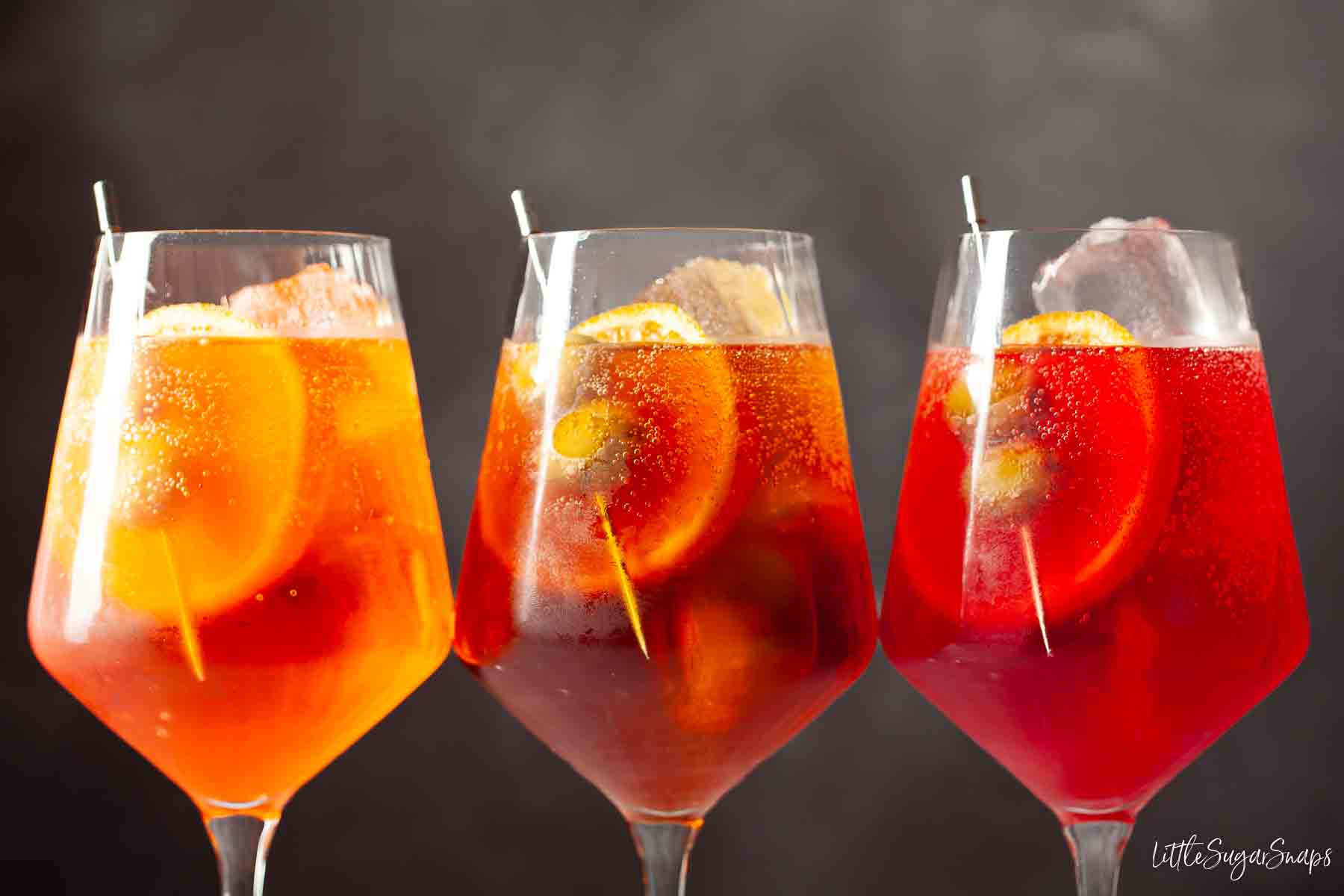 Three versions of spritz Venetiano made with Aperol, Cynar and Campari.