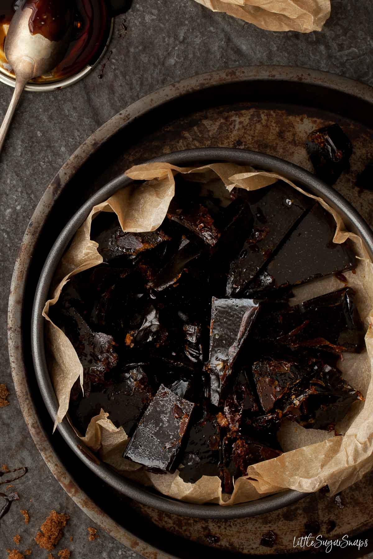 Chunks of black treacle bonfire toffee in a round tin.