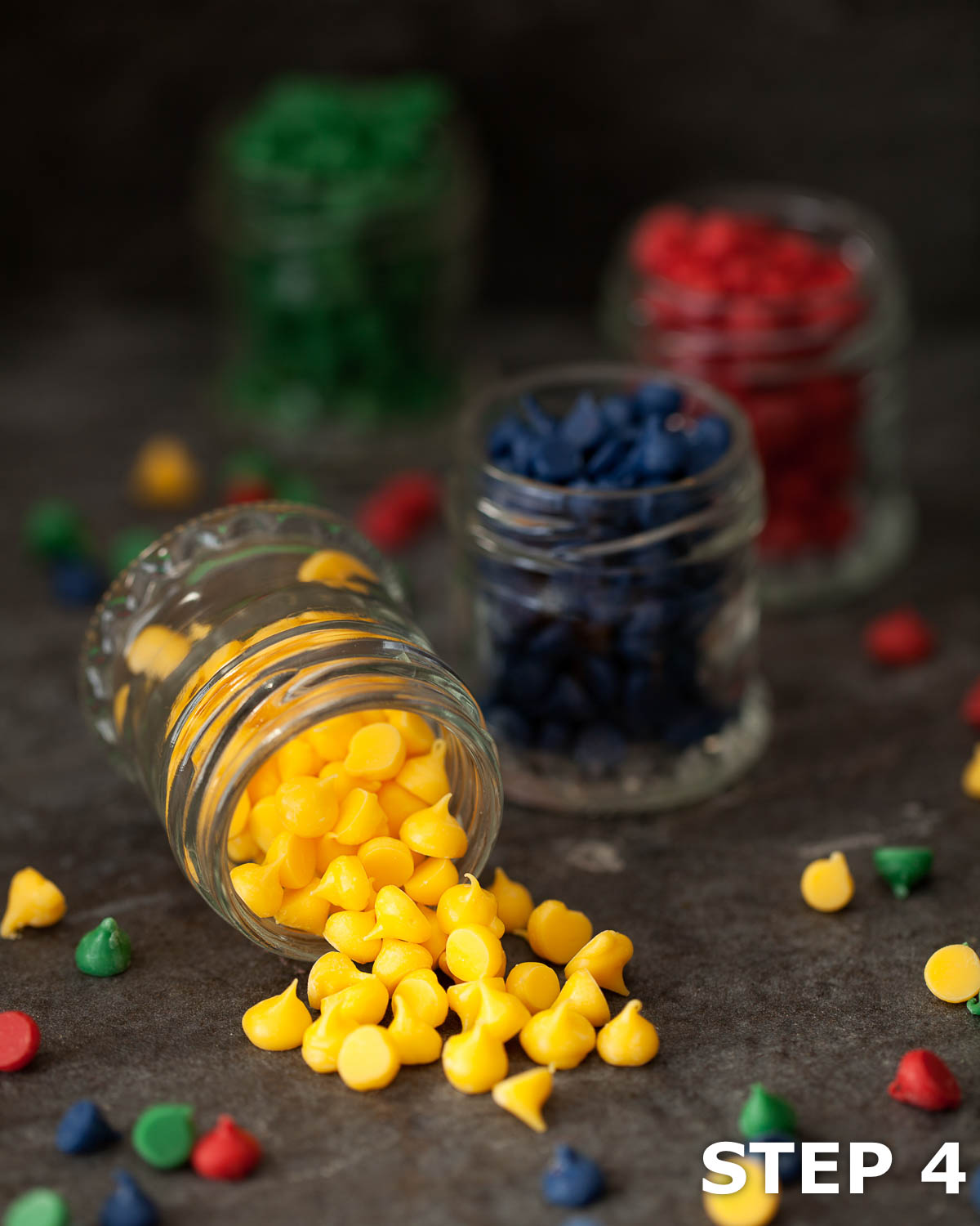 Yellow, blue, green and red Candy Melt drops in sall jars.